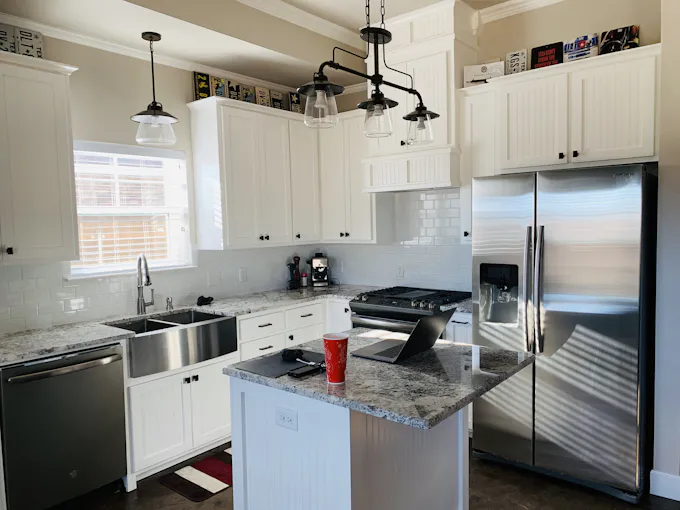 Gray stainless steel side-by-side LG-style refrigerator with water dispenser serviced by an Altoona appliance repair technician