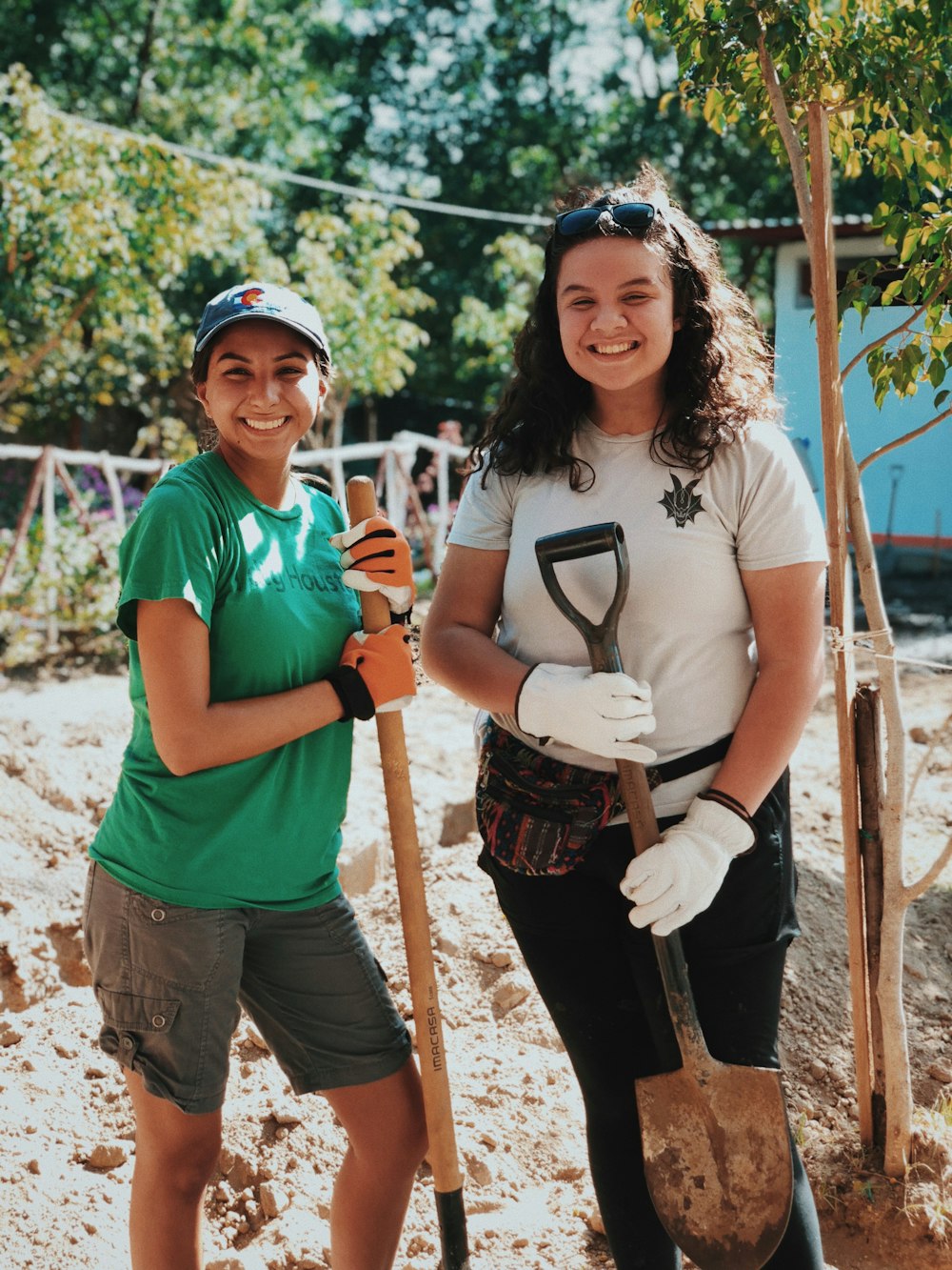 two women holding shovels