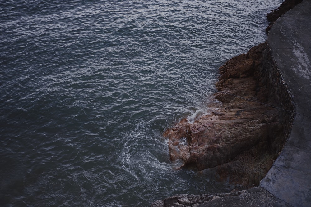 brown stone near sea at daytime