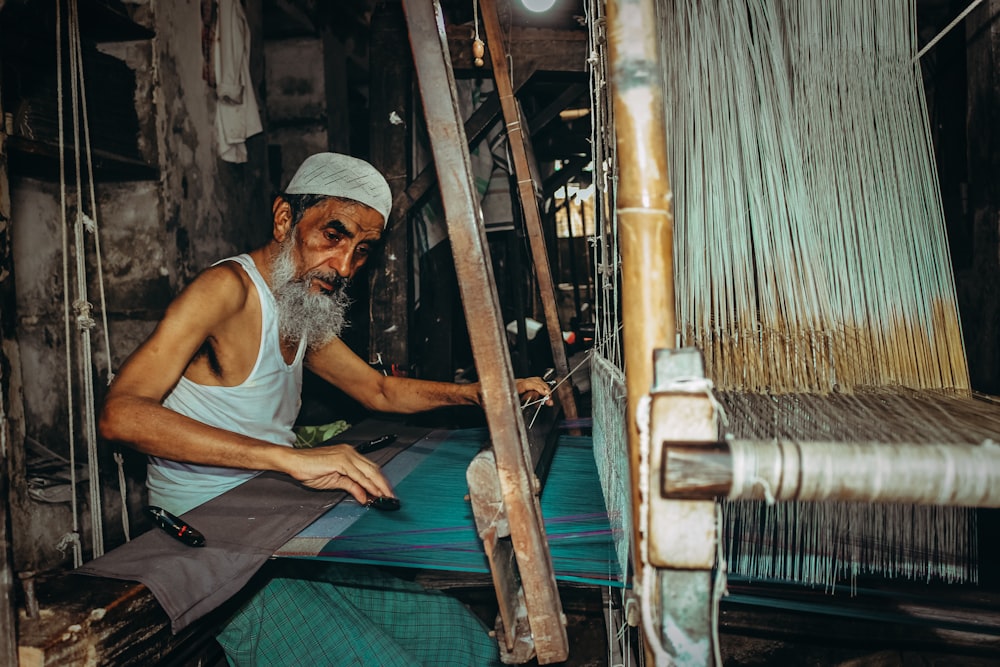 man weaving thread