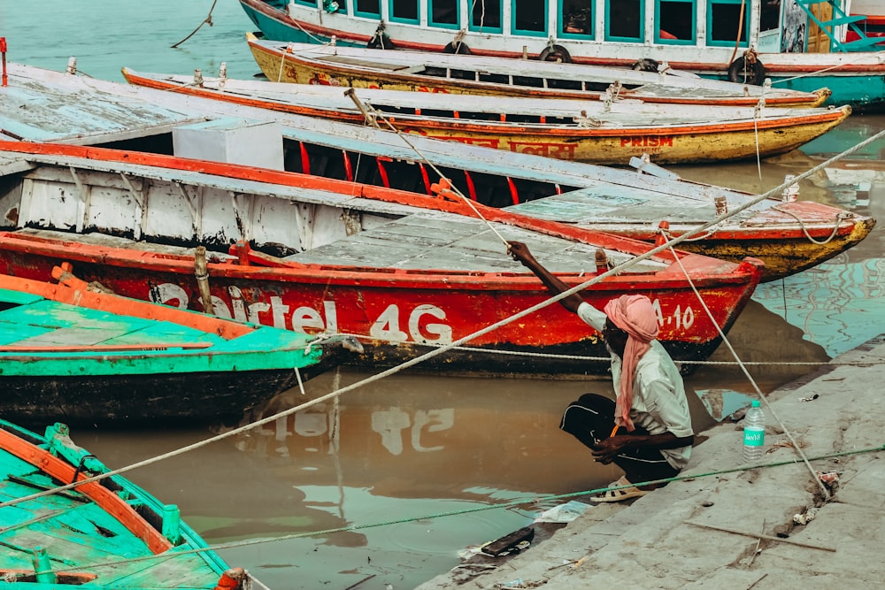 man sitting in fornt of canoe boats