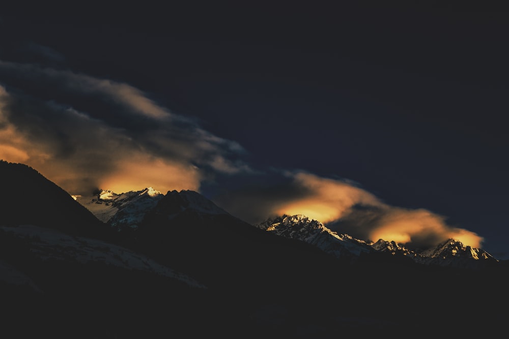 a mountain range covered in clouds at night