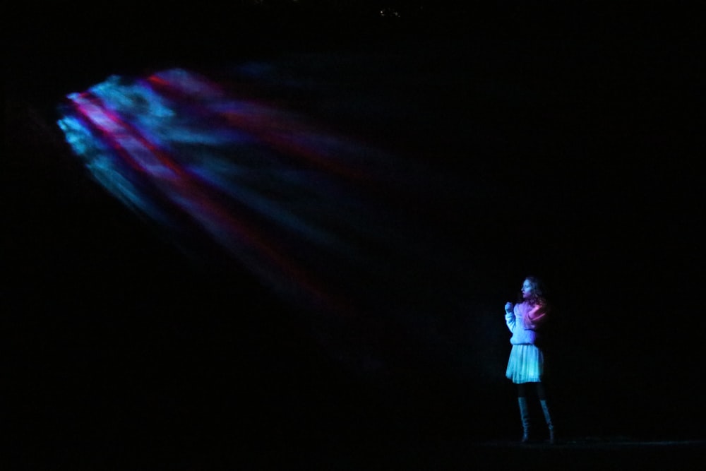 woman standing in the dark while wearing white dress