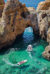 high-angle photography of two power boats surrounded by cliff