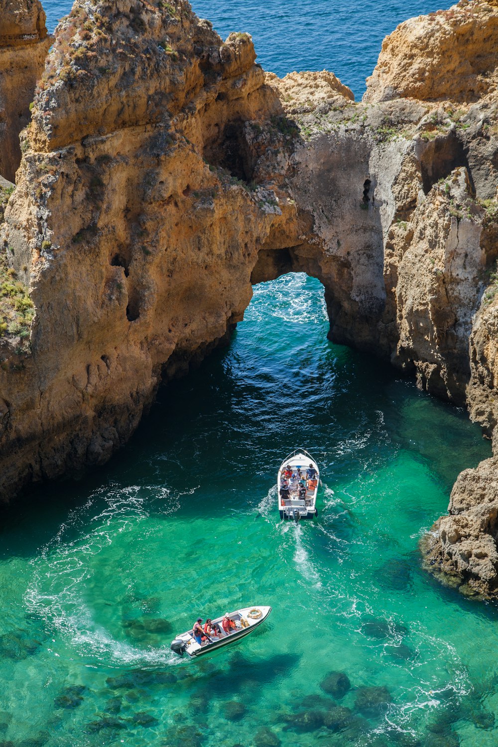 high-angle photography of two power boats surrounded by cliff