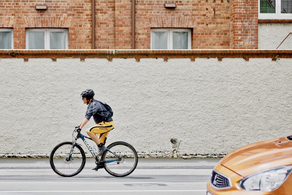 man riding black bike on street