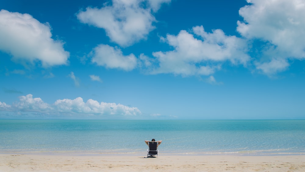 person sitting on seashore