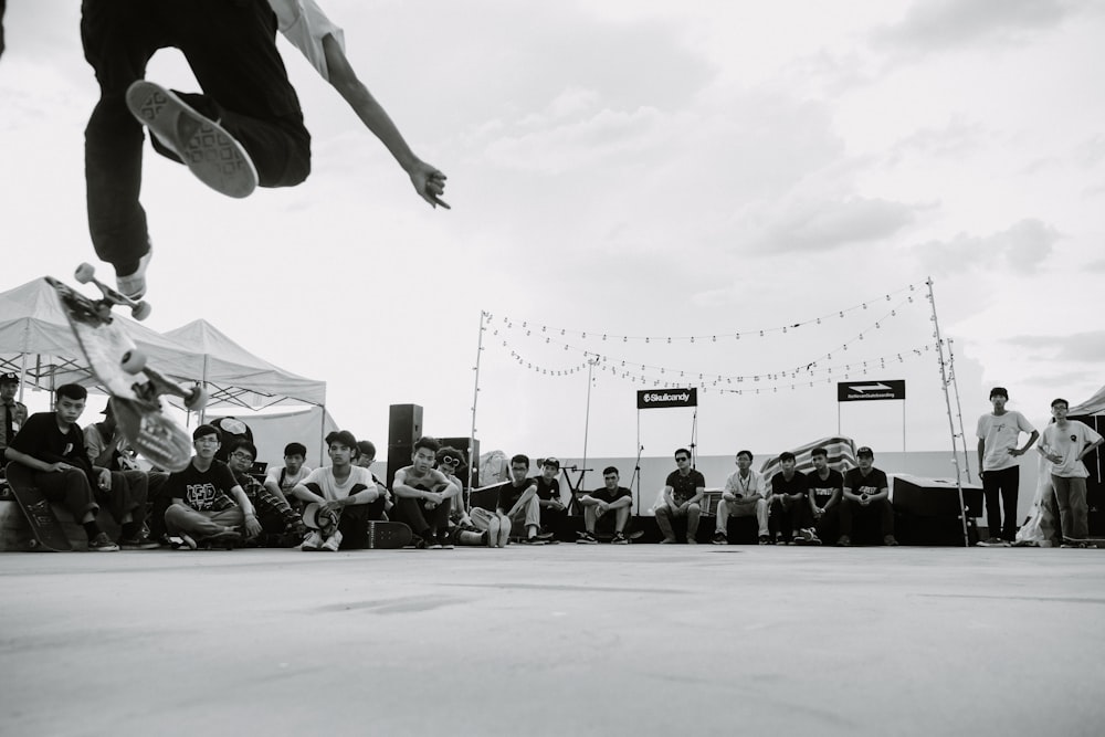 men gathering around man skating during daytime