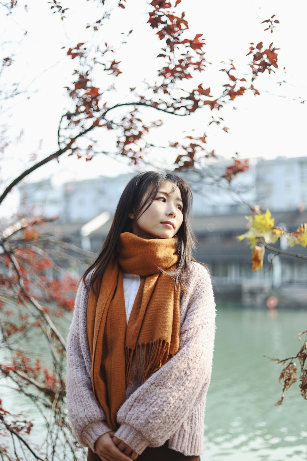 selective focus photography of standing woman beside body of water during daytime