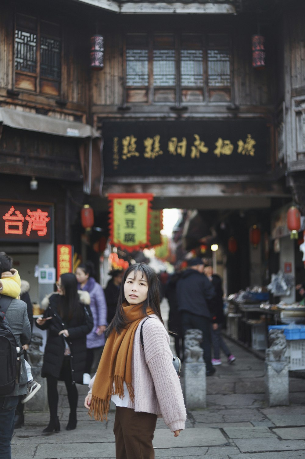 woman wearing brown scaft standing in front of store