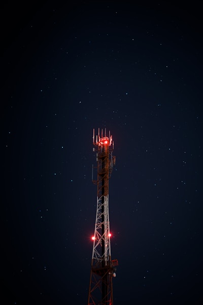 white and red metal satellite tower during nighttime