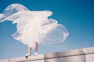 person holding plastic while standing on wall fashion teams background