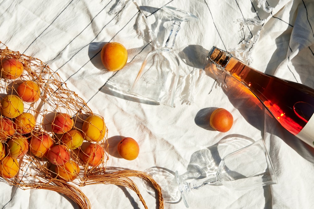 white labeled bottle on white textile and citrus fruits