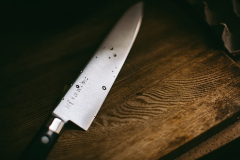 gray knife on brown wooden surface