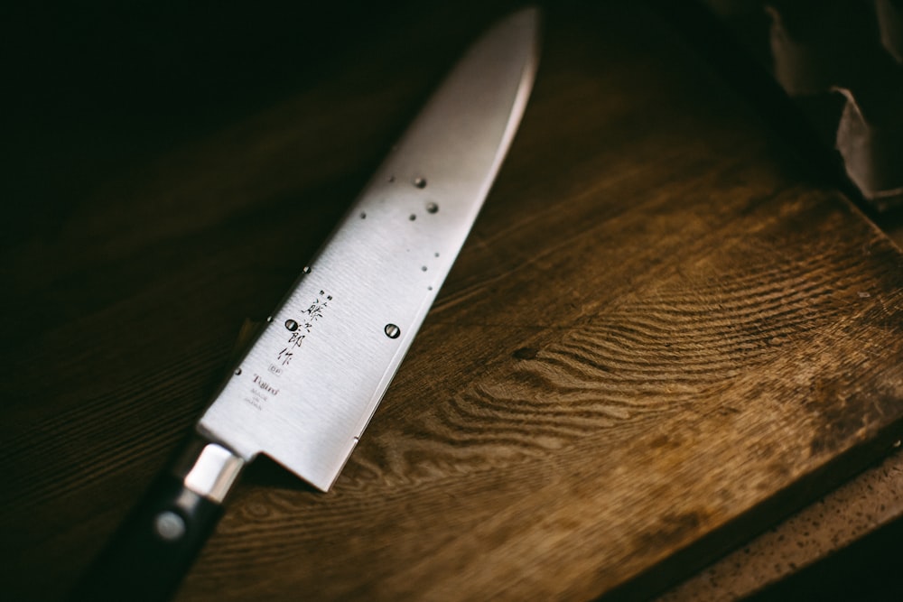 gray knife on brown wooden surface