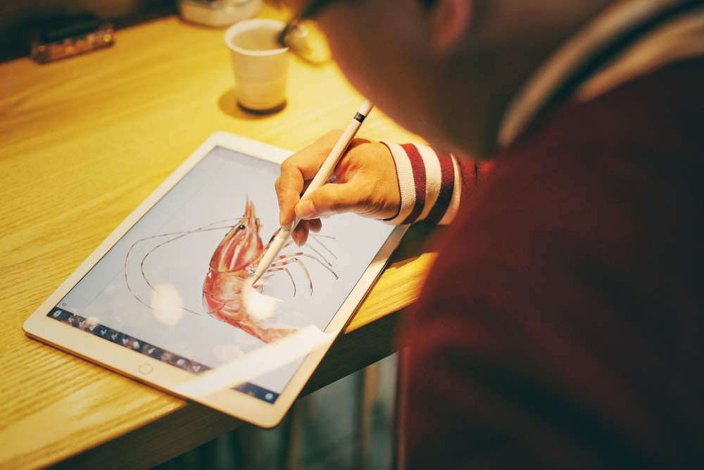 person draw shrimp on iPad