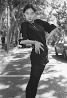 A candid street photo capturing someone wearing a bold oversized t-shirt with a confident pose.