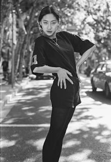 A candid street photo capturing someone wearing a bold oversized t-shirt with a confident pose.