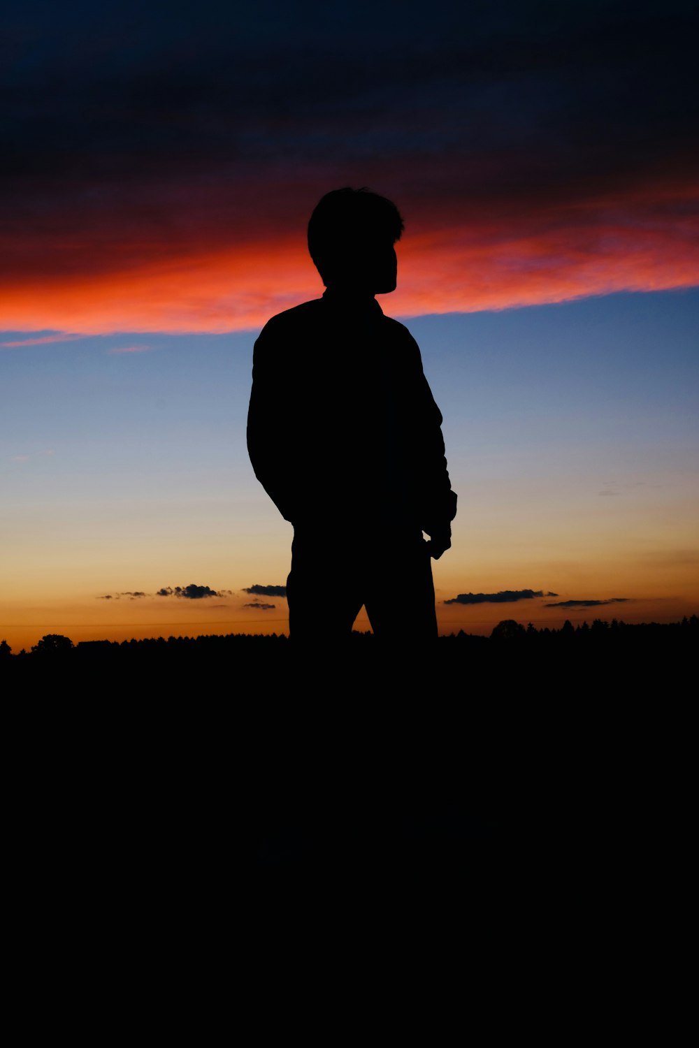 man standing under golden hour silhouette