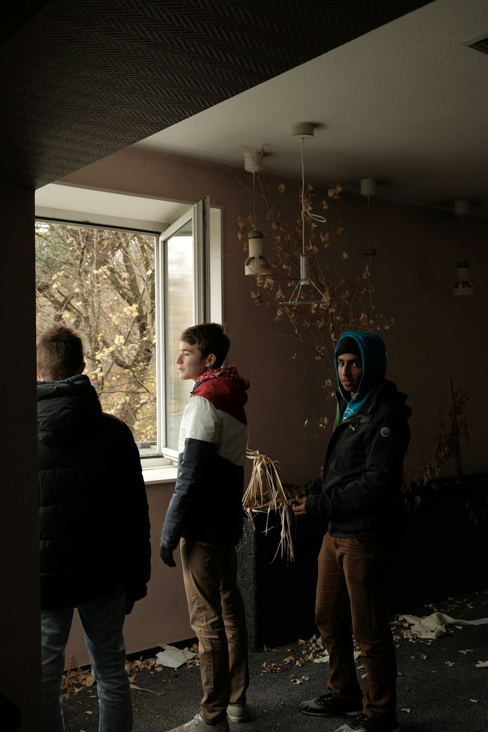 three men wearing jackets inside room