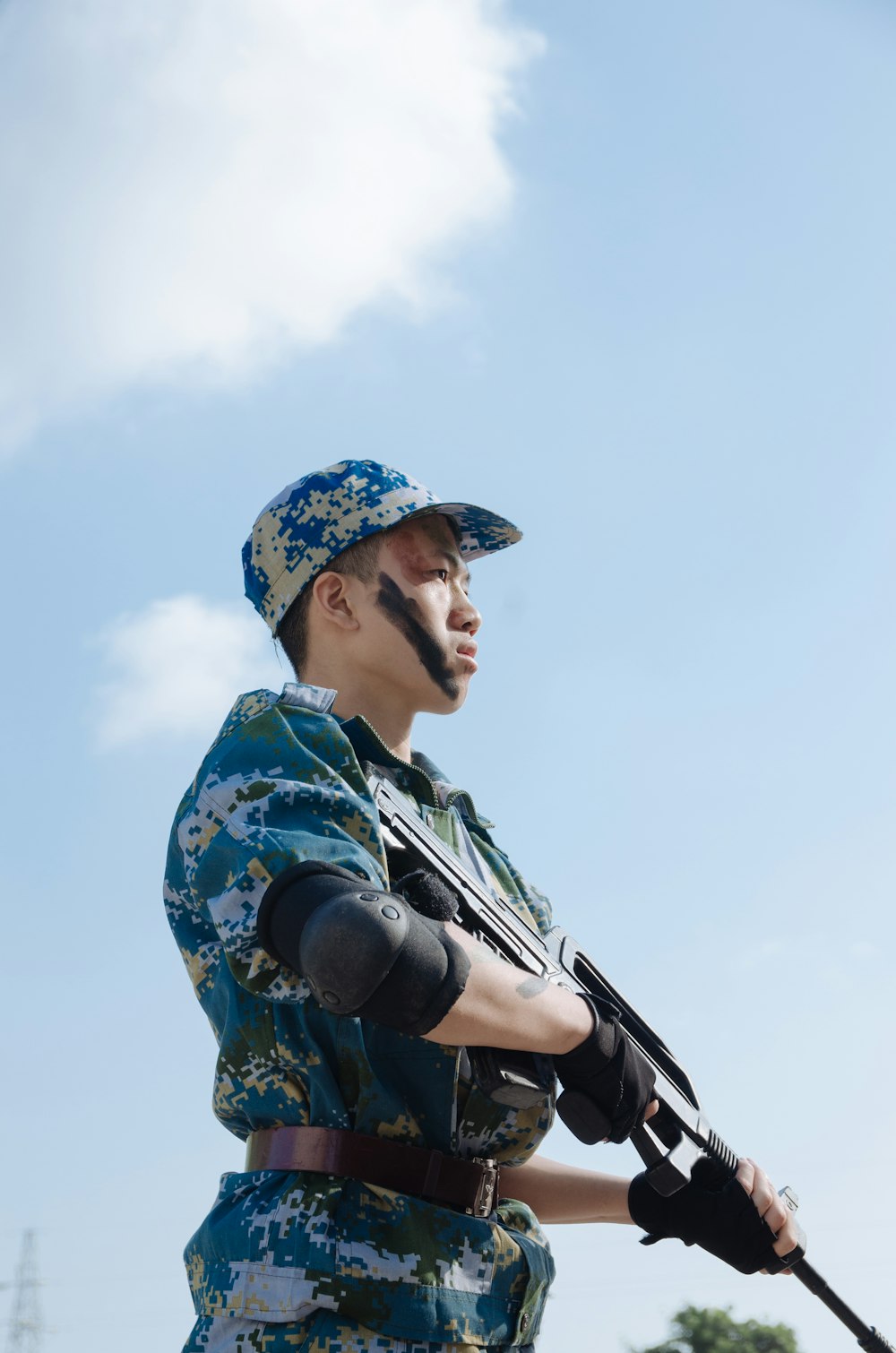 man standing carrying rifle during day