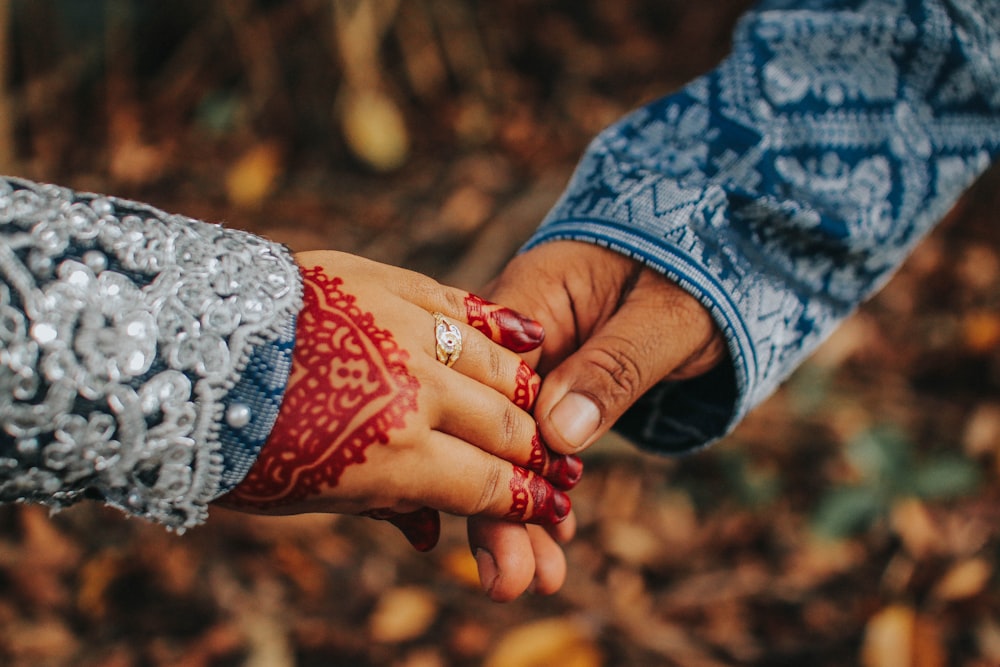 selective focus photography of man and woman holding hands