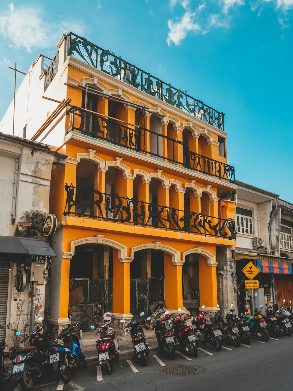 motorcycles parked in front of yellow 3-story building