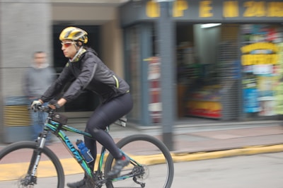 Side view of a person cycling through the city in Mark X Apparel activewear.