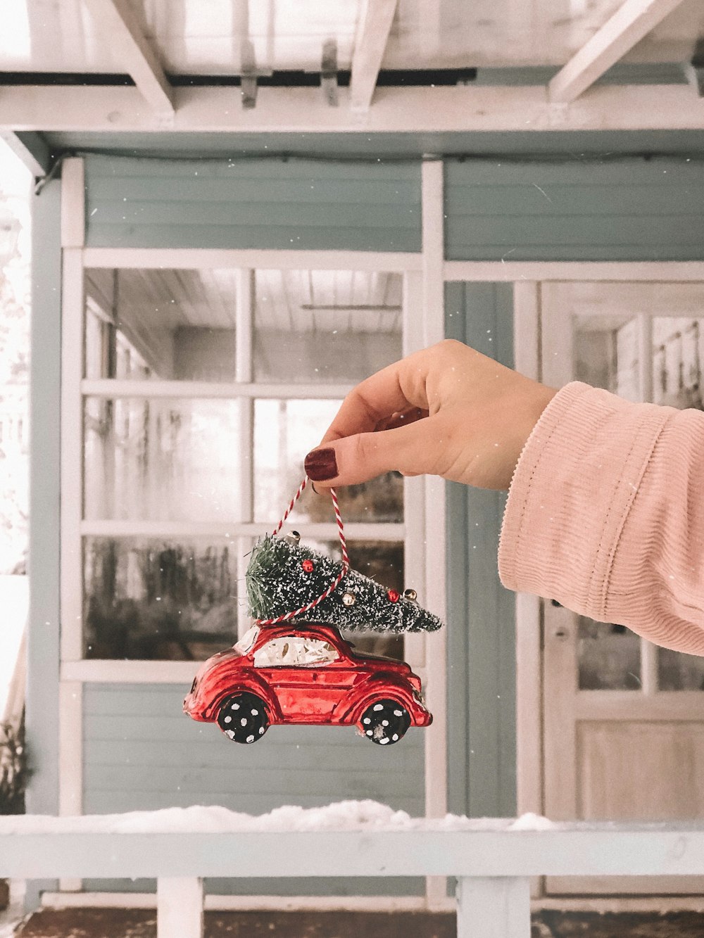 persona che tiene il giocattolo rosso del veicolo che appende la decorazione