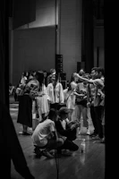 A candid shot of actors preparing backstage, adjusting costumes and makeup.