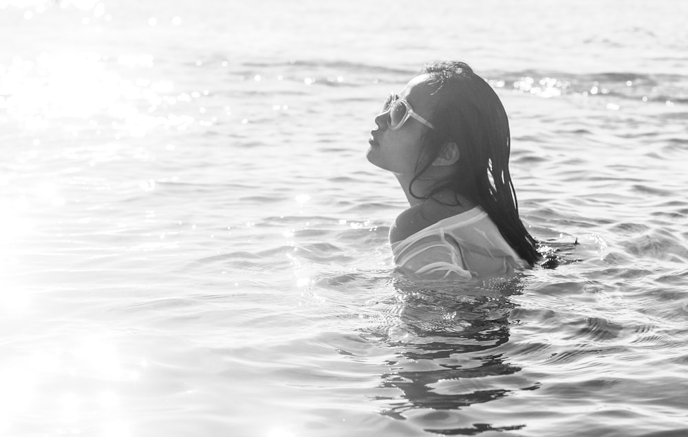 grayscale photography of woman wearing sunglasses swimming