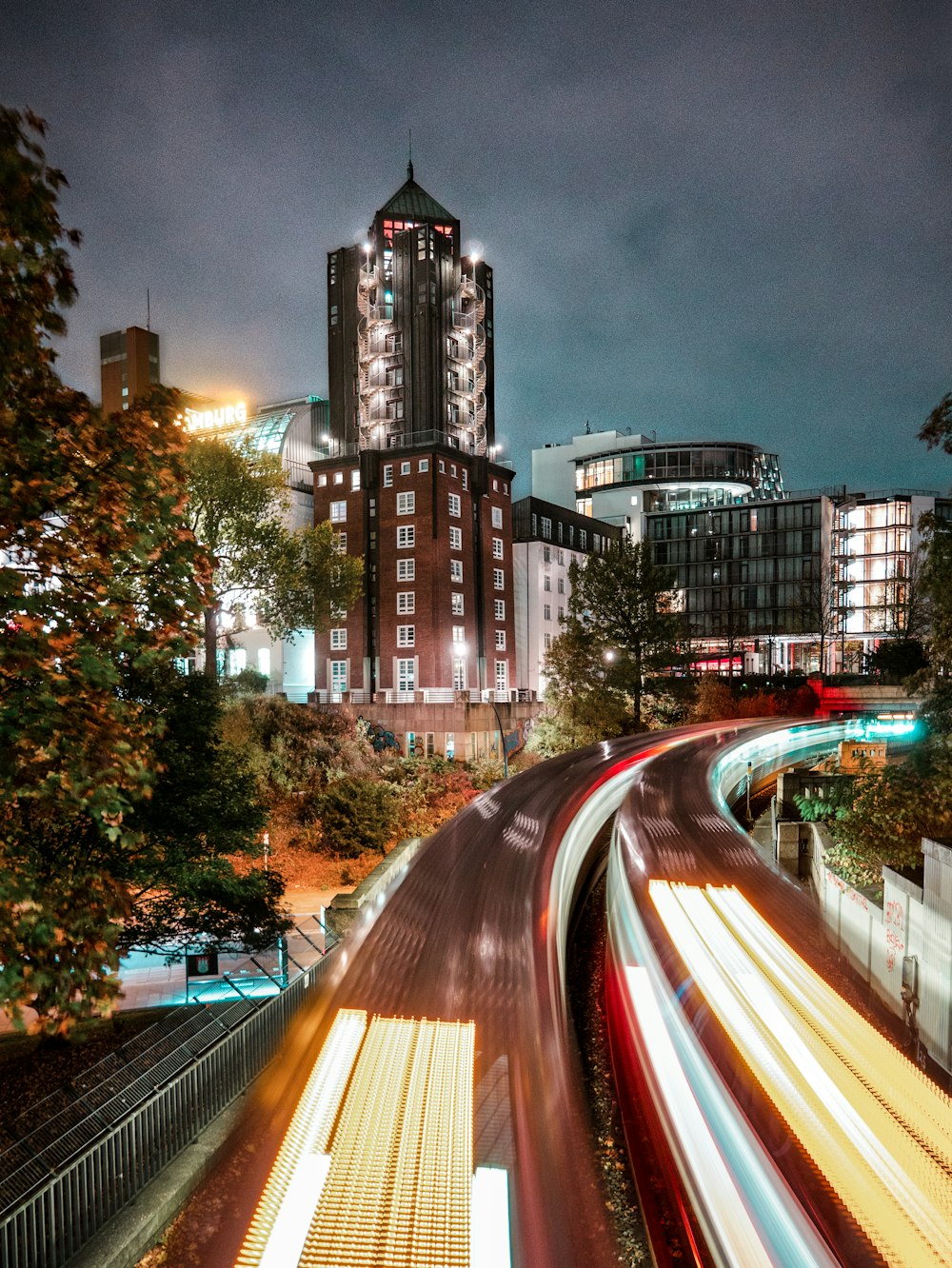 Fotografía timelapse de luces traseras y faros de automóviles con edificios