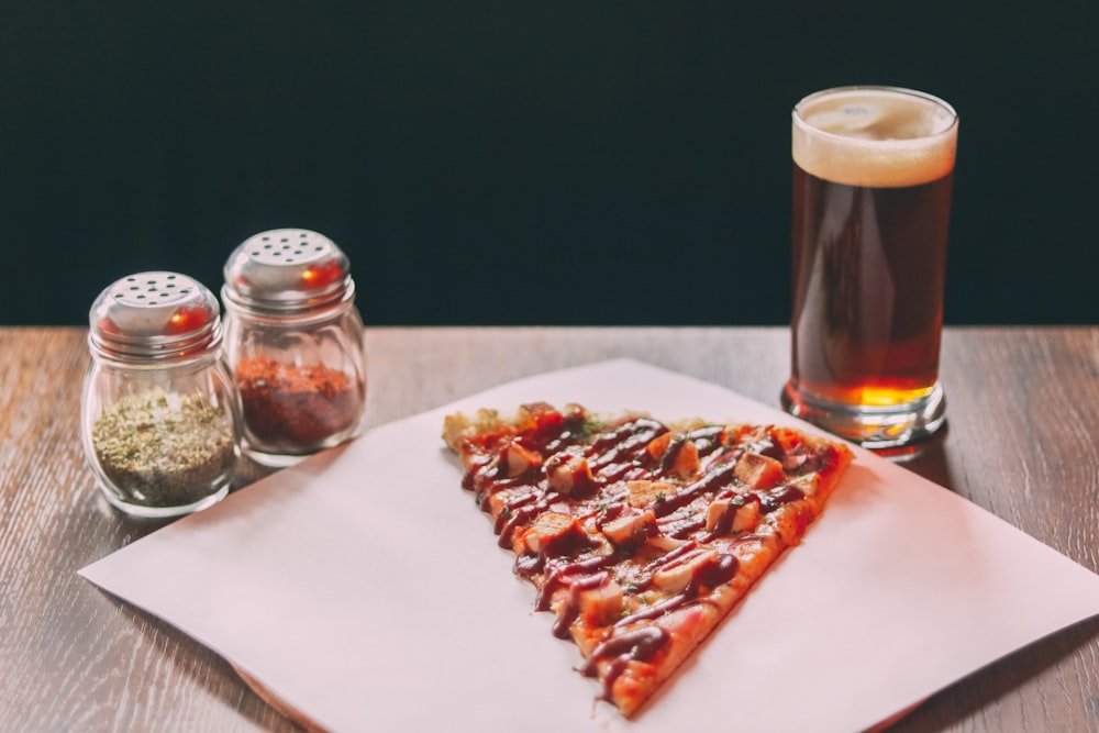 baked pizza beside two clear glass condiment shakers
