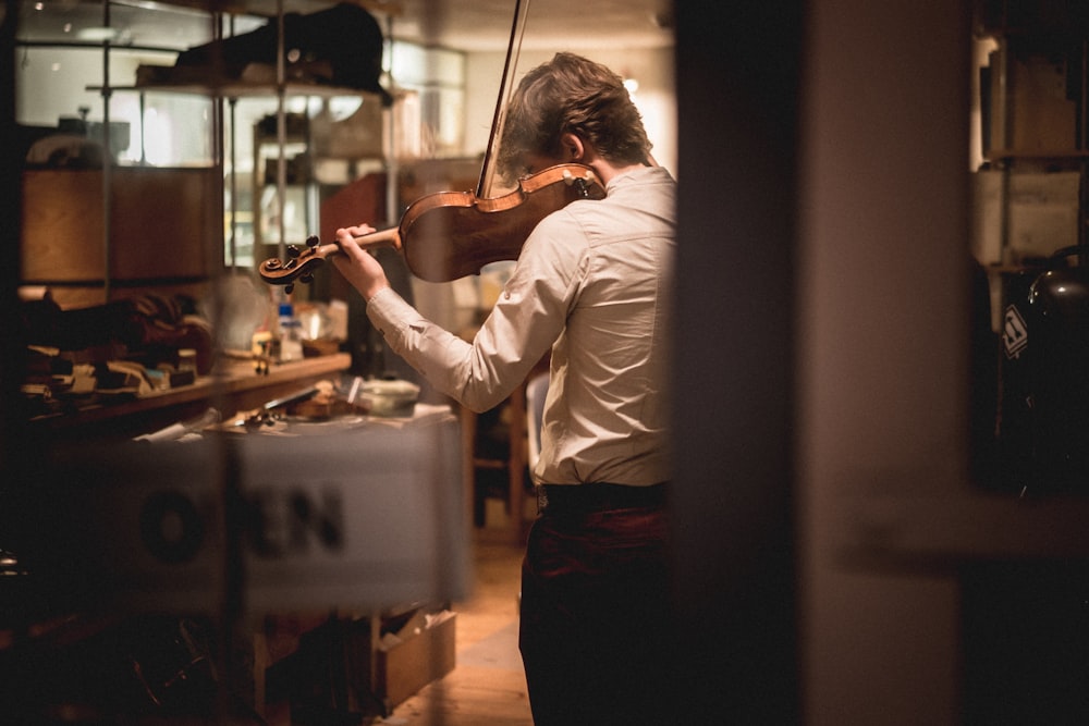 man in white dress shirt playing violin