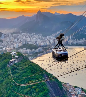 white cable car traversing on top of hills overlooking city by bay