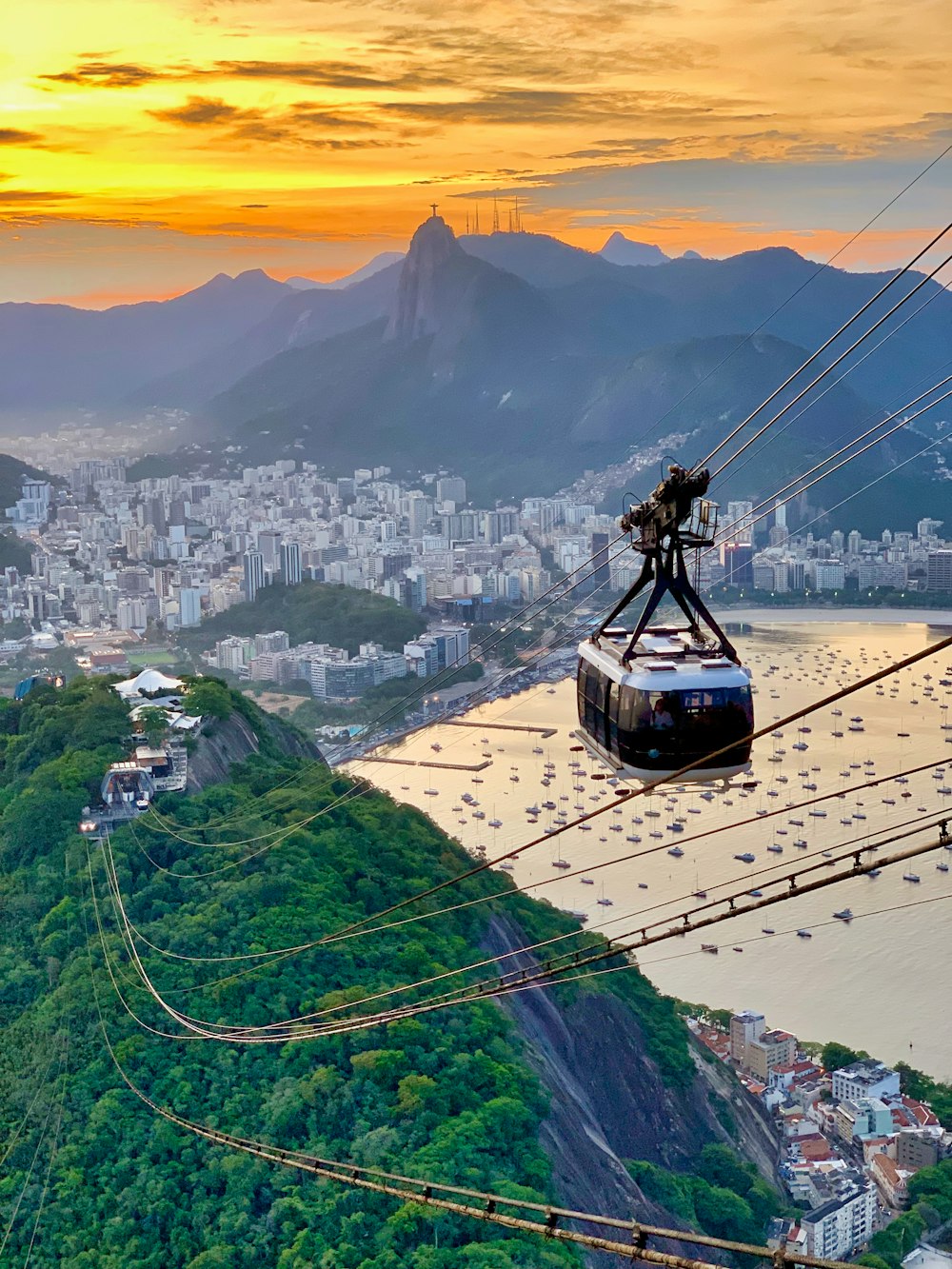 Teleférico blanco que atraviesa la cima de las colinas con vistas a la ciudad por la bahía