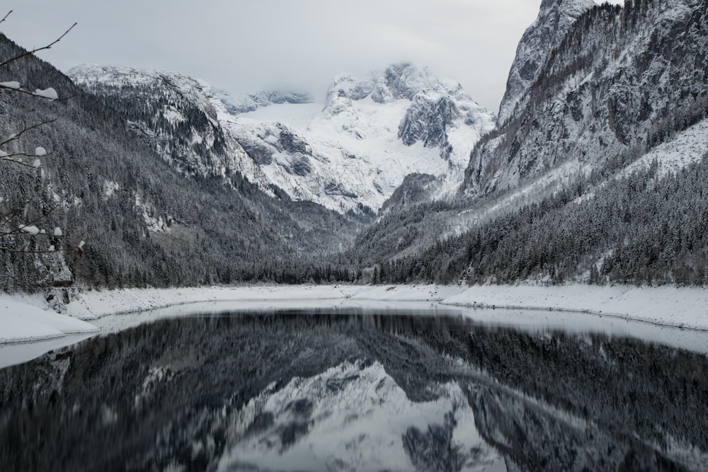 snow covered mountains near body of water during daytime