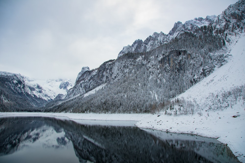 snow covered mountain near body of water