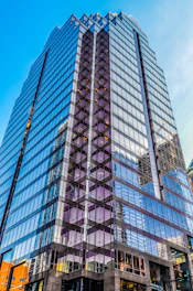 Sophisticated commercial building with glass facade reflecting city skyline.