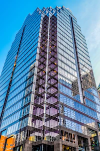 Sophisticated commercial building with glass facade reflecting city skyline.