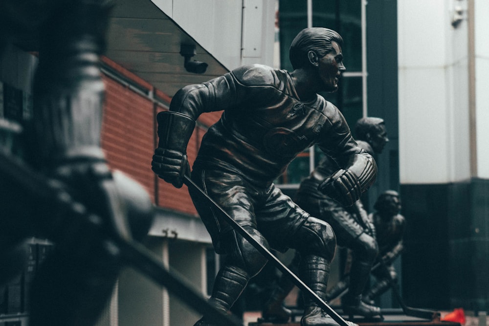 selective focus photography of ice hockey player statues