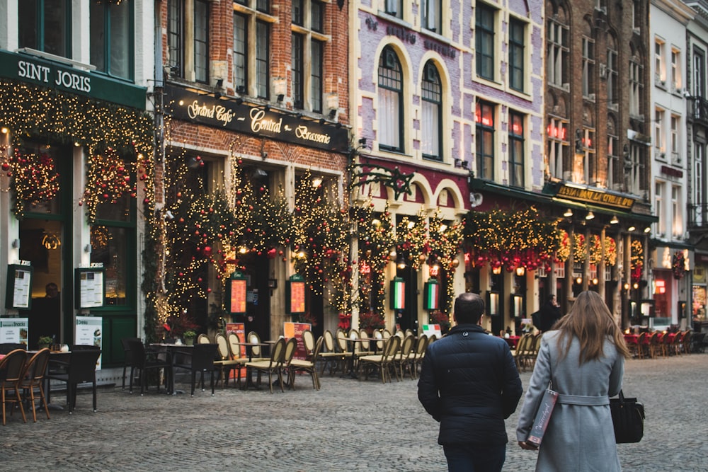 woman and man walking on pavement near building