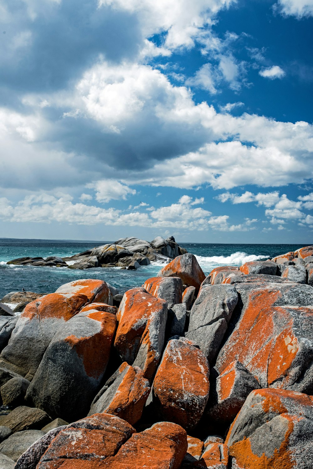 orange and gray stones near body of water during daytime