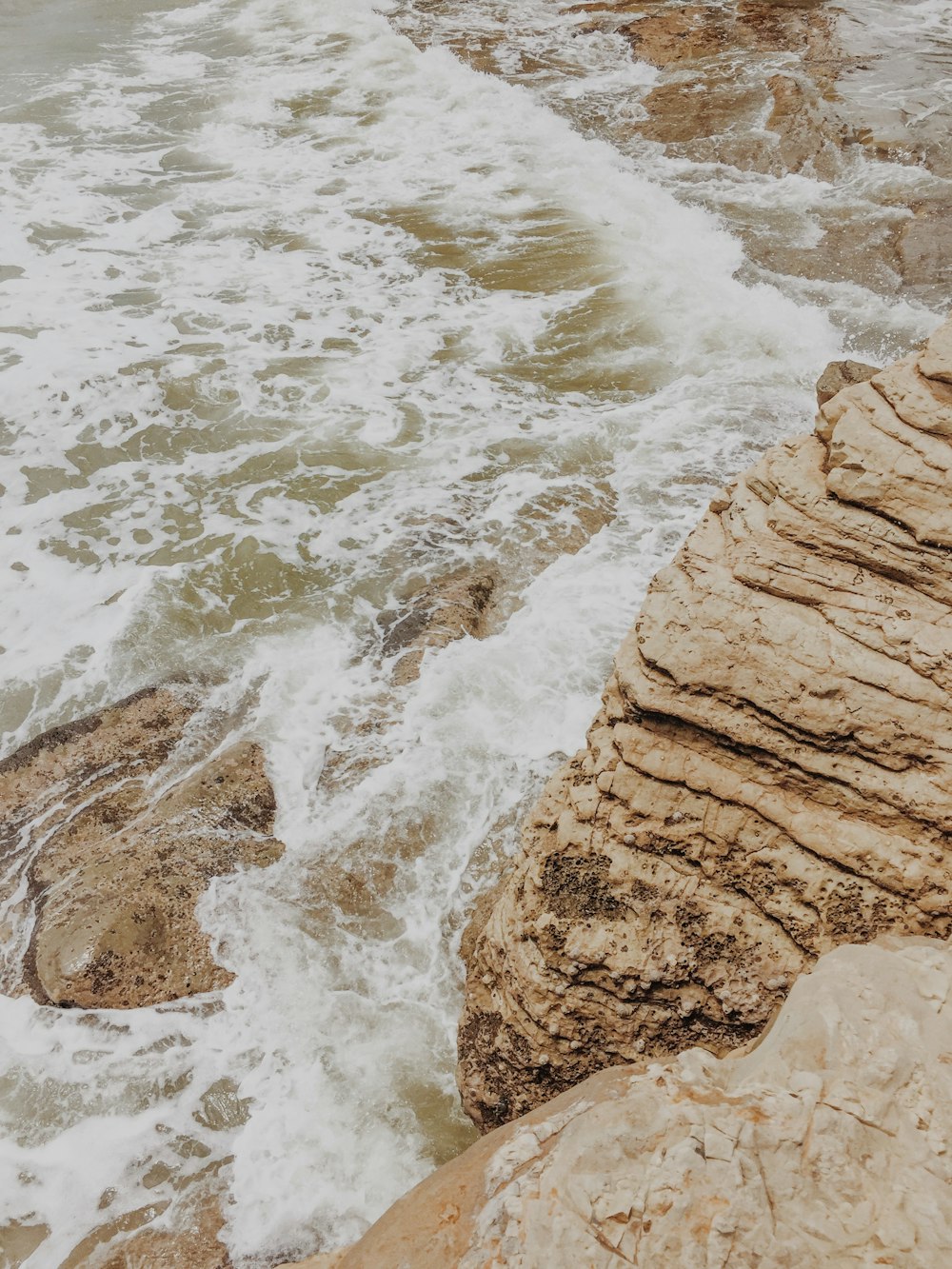 body of water beside rock formation