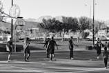 A group of kids playing basketball outdoors, smiling and cheering each other on.
