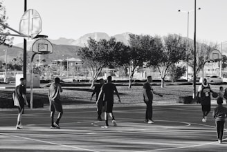 A diverse group of players enjoying a basketball game on an outdoor court.