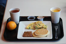 Airline-style breakfast tray with omelet, sausage, pancake and coffee