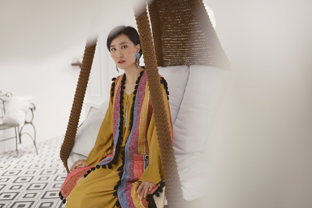 woman sitting on white padded swing bench inside room