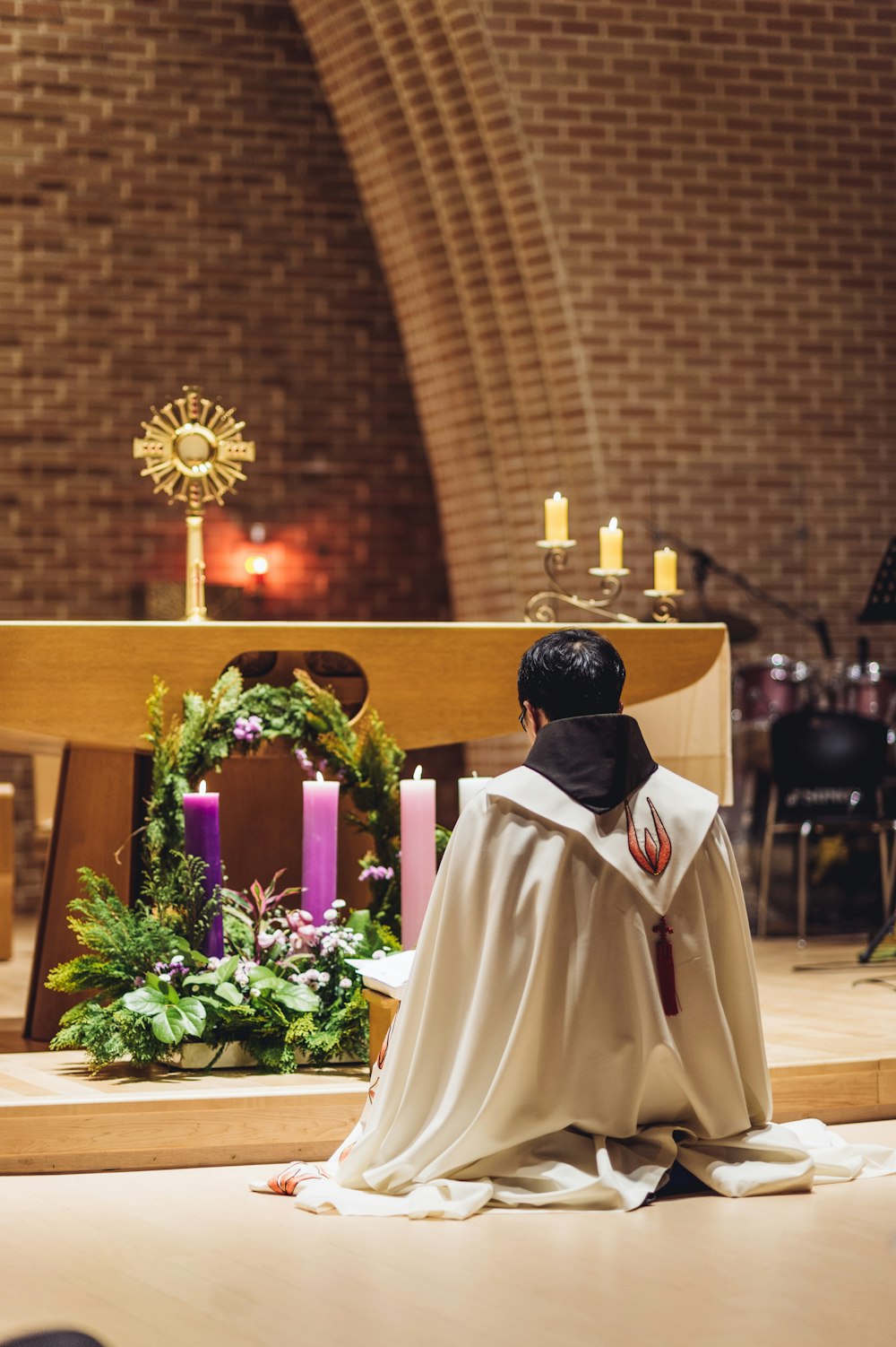 person kneeling in front of altar inside building