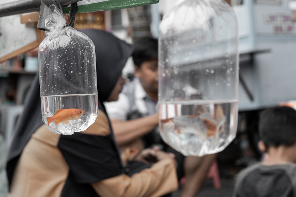 two goldfishes in separate plastic bags with water